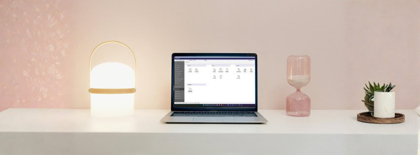 Espacio de trabajo con ordenador portátil, lámpara y plantas para pymes.